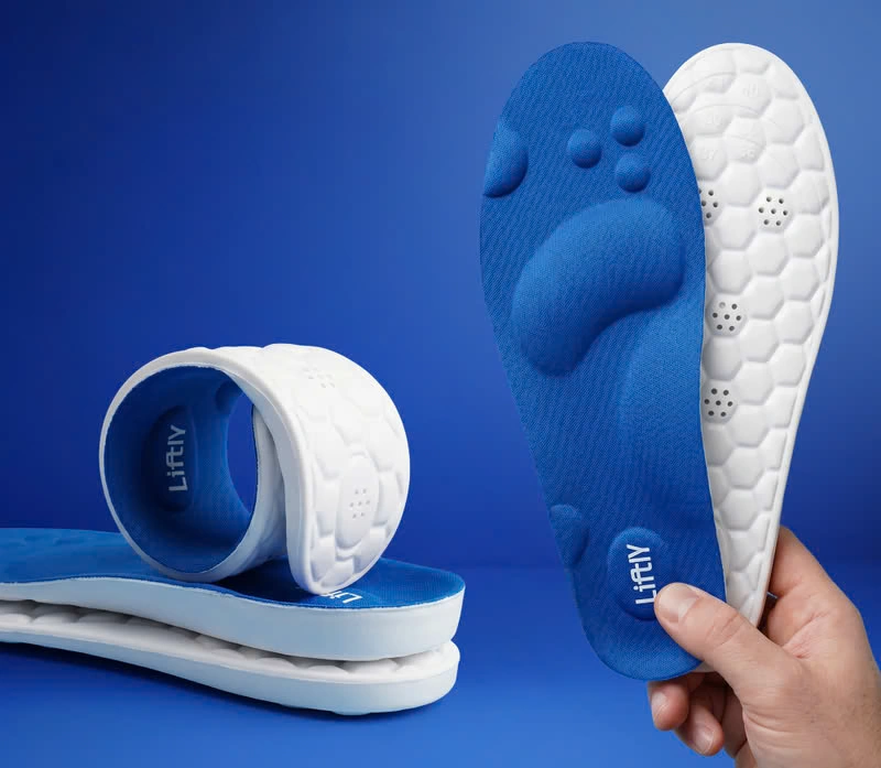 Flexible Liftly insoles rolled and stacked, with a hand holding a pair